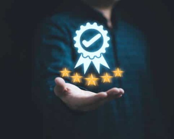 Businessman holding and showing the best quality assurance with golden five stars for guarantee product and ISO service concept.
